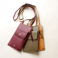 Three leather handbags in different colors on a light background