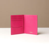 Pink leather wallet open on a neutral background
