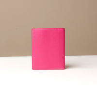 Pink leather passport case on a neutral background
