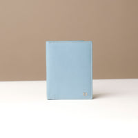 Light blue passport holder on a beige background