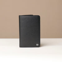 Front view of a danilos travel pro passport case lux in black pebble leather in a beige background