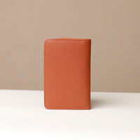 back view of a danilos travel pro passport case lux in brown pebble leather in a beige background
