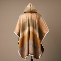 Hooded blanket with brown and beige pattern on a mannequin against a brown background
