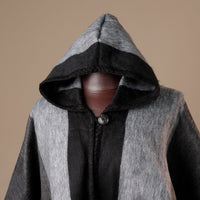 Gray and black hooded garment on a neutral background