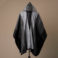 Gray hooded cape on a mannequin against a brown background