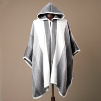 Gray and white hooded poncho on a mannequin against a brown background