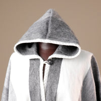 Gray and white hooded garment on a mannequin against a beige background