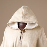 Beige hooded cloak with a zipper on a neutral background