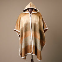 Hooded cape with plaid pattern on a mannequin against a brown background