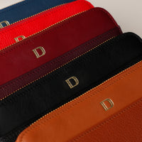 Close-up of leather bags with gold lettering on a white background