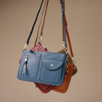 Blue handbag with gold accents on a beige background