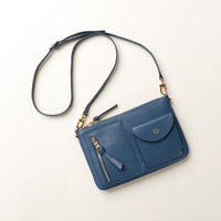 Blue handbag with a strap on a light beige background