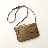 Green handbag with a strap on a white background