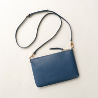 Blue handbag with a strap on a light beige background