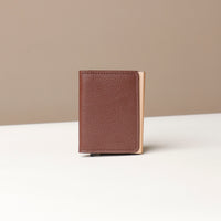 A brown RFID blocking card case wallet with a pebble texture and a magnetic closure, displayed against a neutral background.