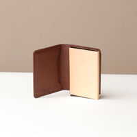 Brown wallet with beige interior on a neutral background