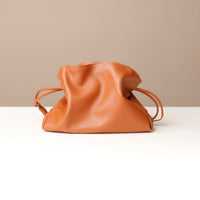 Brown leather drawstring bag on a beige background