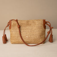 Sassy Satchel 26 Raffia Pana handcrafted with raffia and premium leather, with a pana leather strap, in a beige background, front view
