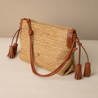 Sassy Satchel 26 Raffia Pana handcrafted with raffia and premium leather, with a pana leather strap, in a beige background, lateral view

