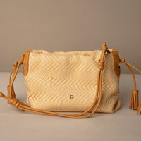 Sassy Satchel 26 Raffia Mostaza handcrafted with raffia and premium leather, with a mostaza leather strap, in a beige background, front view
