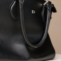 Close-up of black leather handles – Saule Tote by Danilo’s with precision-crafted finishing and silver D
