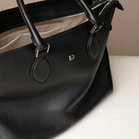 Close-up of black leather handles – Saule Tote by Danilo’s with precision-crafted finishing and silver D