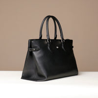 Front angled view of black leather Saule Tote – elegant work tote with top handles and clean silhouette