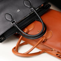Close-up of D emblem on Saule black leather tote – minimal branding for timeless appeal