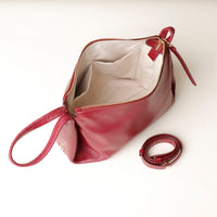 Red handbag with a strap on a white background