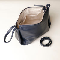 Navy blue handbag with beige interior on a white background