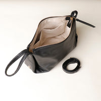 Black leather handbag with a strap on a white background