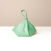Mint green handbag with a handle on a beige background