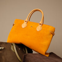 Yellow suede leather danilos  tote bag with brown leather accents on a neutral background