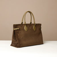 green suede leather danilos tote bag with green handles on a beige background