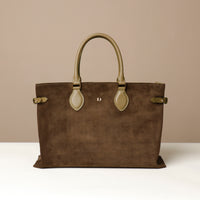 green suede leather danilos  tote bag with matching handles on a beige background