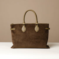 green suede leather danilos  tote bag with green handles on a beige background