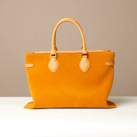 Yellow suede leather danilos  totebag with yellow handles and accents on a beige background
