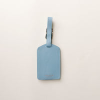 Blue luggage tag on a light gray background