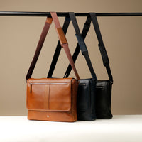 Two messenger bags, one in brown and one in black, made of premium pebbled Napa leather, displayed side by side with adjustable straps.