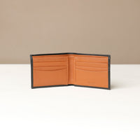 Front of an open black pebble leather Milano wallet with an orange inside, eight visible slots