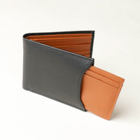 Front of a black pebble leather Milano wallet with a orange card case holder that comes out of one of the sides