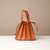 Brown leather handbag on a beige background