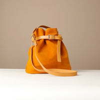 Yellow handbag with a strap on a beige background