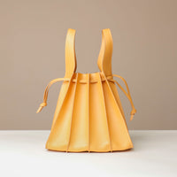 Yellow pleated bag on a beige background