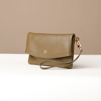 Side view of a olive green leather Karelia Clutch Danilos with a visible hand strap over a white and beige background