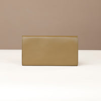 back view of a danilos clucth versaviva in olive green leather in a beige background