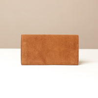 Brown suede Danilos clutch bag on a beige background