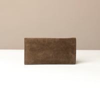 Brown leather Danilos wallet on a white surface with a beige background
