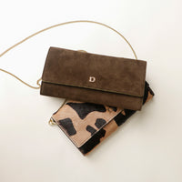 Brown suede Danilos clutch with gold chain and camouflage pattern on a white background