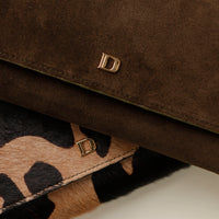 Close-up of a brown leather Danilos clutch wallet with a gold logo and leopard print strap.